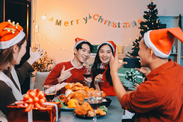 Group of young Asian man and women as friends having fun at a New Year's celebration, holding gift...