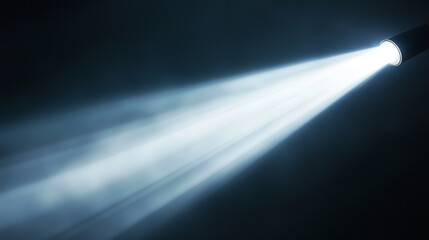 Bright spotlight beam cutting through dark atmosphere with visible light rays. Minimal background for design