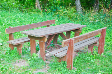 Fototapeta premium EMPTY WOODEN PICNIC TABLE WITH BENCHES in a public park