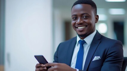 Fototapeta premium A smiling man in a suit using a smartphone in an office setting.