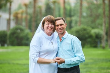 Obraz premium An adult bride and groom. Husband and wife's wedding anniversary photo shoot. We've been together for 30 years.