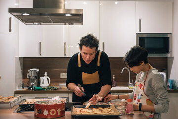 Mother and daughter making Christmas cookies at home
