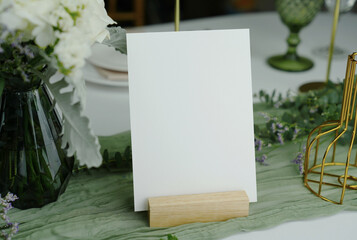 Blank card mockup for wedding invitations, place cards, table numbers, or menus. Set against a wedding table background. with clipping path