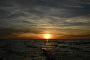Serene ocean sunset with dramatic sky.