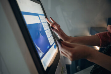 Touch screen, modern technology. Woman is using banking terminal indoors