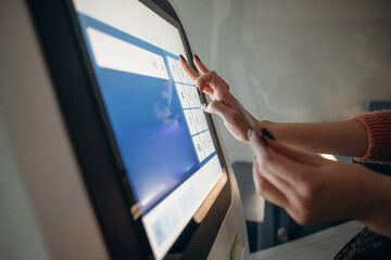 Naklejka premium Touch screen, modern technology. Woman is using banking terminal indoors