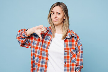 Young sad displeased dissatisfied woman wear red shirt t-shirt casual clothes showing thumb down...