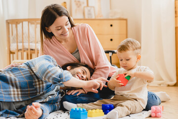 Young caucasian family of three, parents, mother and father playing developing games with toddler...