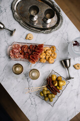 Appitizers, metal short glasses, randomly lying on a marble table, top view, flay lay 