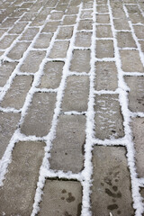 Frosted patio, ice and snow in the joints of the pavers