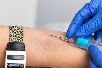 Nurse taking a blood sample from a patients arm