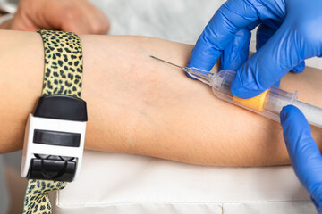 Nurse taking a blood sample from a patients arm