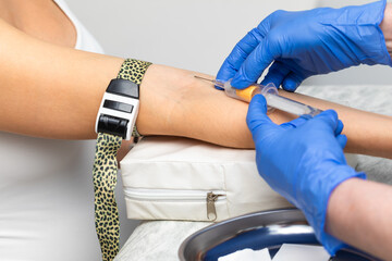 Nurse taking a blood sample from a patients arm
