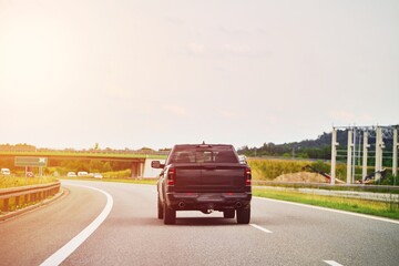 Black pickup truck driving on an open highway
