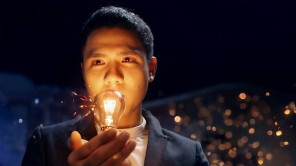 Empresario sosteniendo una bombilla con un efecto brillante sobre un fondo oscuro, pensamiento innovador para una nueva idea de plan de negocios e ideas de diseño creativo.	