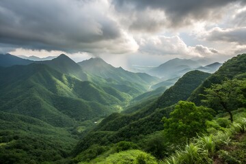 Obraz premium Scenic view of lush green mountains under a cloudy sky.