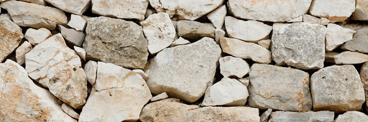 Beige stonework stone texture background, close-up panoramic image