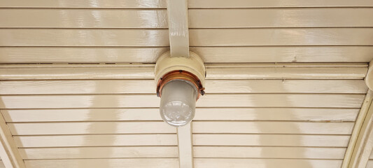 Wooden ceiling of a vintage tram carriage with round lamp