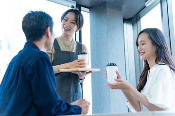 お客様に飲み物を渡す女性店員