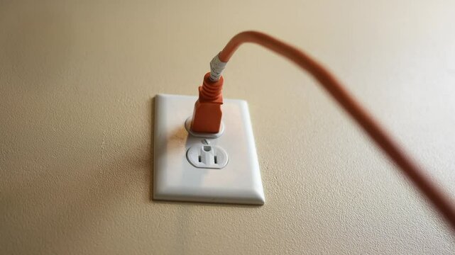 A contractor plugs in an extension cord into outlet in modern home - 2