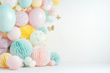 Pastel balloons and paper decorations on white background with copy space. Festive craft party...