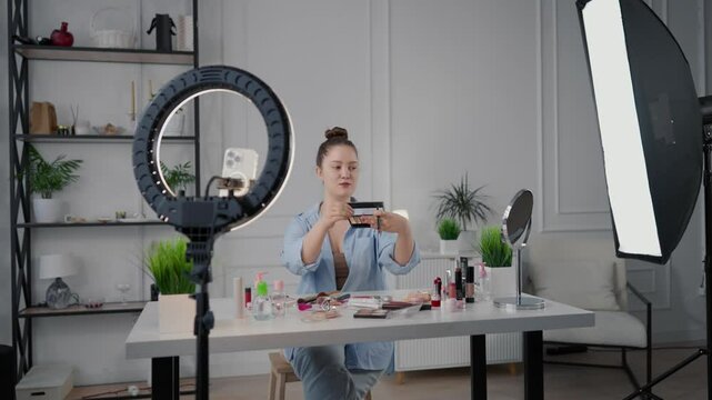 Beauty blogger woman filming review on cosmetic brushes in home studio, stream. Influencer of beauty industry demonstrating new brushes for makeup, native advertisement for followers in social media