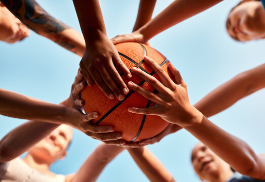 Basketball, hands and people with ball for fitness, support or motivation in outdoor activity or teamwork. Sports game, huddle and group of athletes in low angle for practice, exercise or training