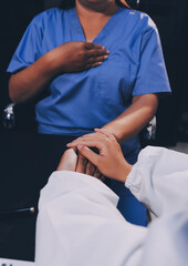 Kind male doctor wearing white coat consulting elder senior female patient holding hand of older woman giving help, safety, empathy and support, showing care and compassion concept. Close up view