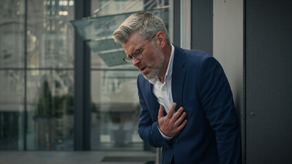 Old senior ill unhealthy unwell employer business man stressed mature businessman chest with pain...