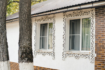 old house with windows. White house with carved windows. Guest house. House at the recreation center.