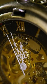 Golden hipster antique elegant pocket watch ticking, five minutes to midnight, on a blurred background, extreme close up shot. New Year's Eve countdown concept.