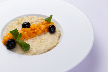 Porridge with pumpkin in a plate on a white background.