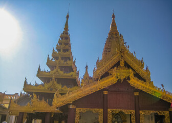 Fototapeta premium Tourist sitting and praying to Shwezigon pagoda an iconic ancient pagoda in Bagan kingdom of Myanmar.