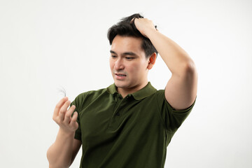 Concerned man inspecting a hair strand, highlighting hair loss or thinning hair issues