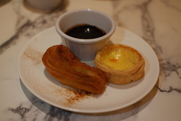 Delicious Dessert Trio with Churros, Custard Tart, and Chocolate Dip