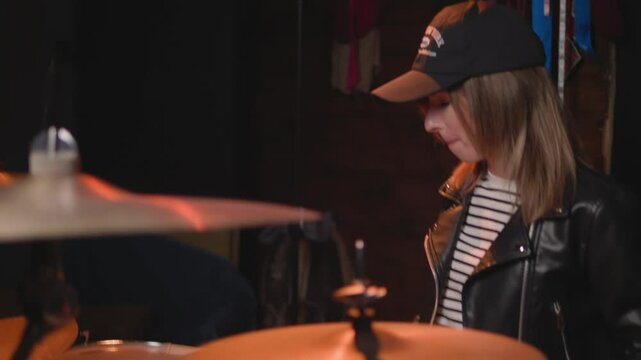 
a girl learns to play the drums