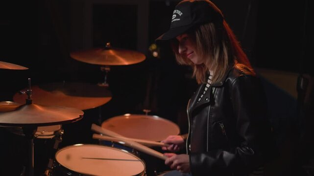 
a girl learns to play the drums