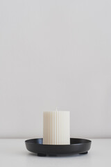 Handmade Soy wax pillar candle on a metal tray. Hygge concept. Minimalist home decor idea