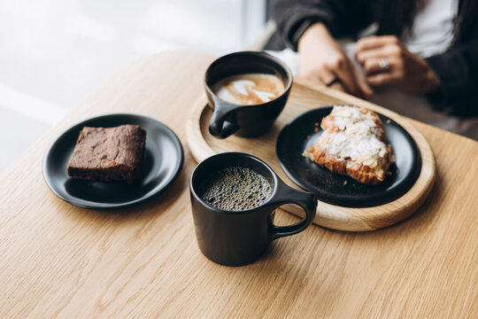 Woman enjoys coffee and pastries at a modern cafe