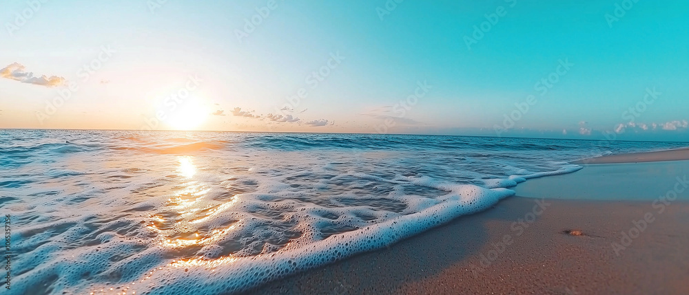 Poster serene beach scene with sun setting over horizon, casting warm glow on ocean waves gently lapping sa