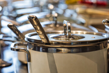 Obraz premium buffet serving station, ceramic non stick saucepan pot with glass lids warming the food