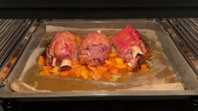 Pork knuckle baked on a baking sheet in the oven. Delicious restaurant or homemade dish for a festive lunch or dinner. Fatty high-calorie male food. Oven-cooked meat