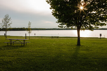 An evening starburst of the setting sun is captured filtering through the maple tree along the...