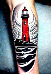  This is an image of a tattoo on someone's arm. It features a lighthouse with waves, and the waves are in motion.