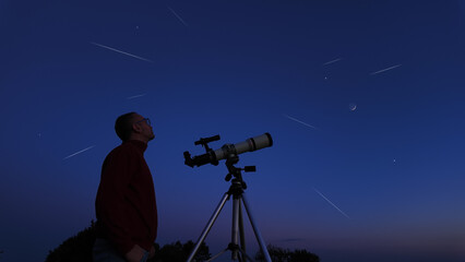 Amateur astronomer looking at the evening skies, observing planets, stars, Moon and other celestial...