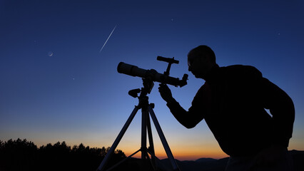 Amateur astronomer looking at the evening skies, observing planets, stars, Moon and other celestial...