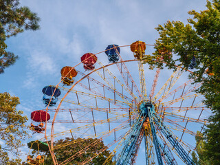 Colorful panoramic observation wheel of Soviet era on a sunny autumn day in an urban city Peremohy park in Kyiv, Ukraine.