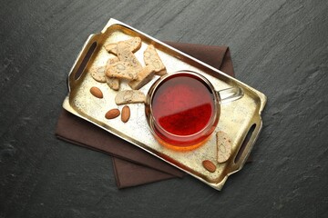 Traditional Italian almond biscuits (Cantucci), nuts and cup of tea on grey textured table, top view