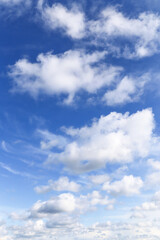 Obraz premium Blue cloudy sky with many beautiful white fluffy cumulus light clouds in sunlight background texture