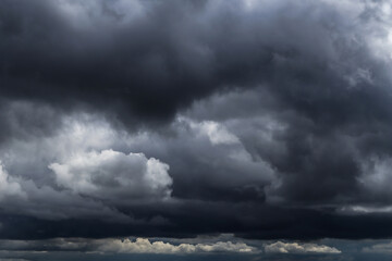 Obraz premium Epic Dramatic storm dark grey black cumulus rain clouds sky background texture, thunderstorm